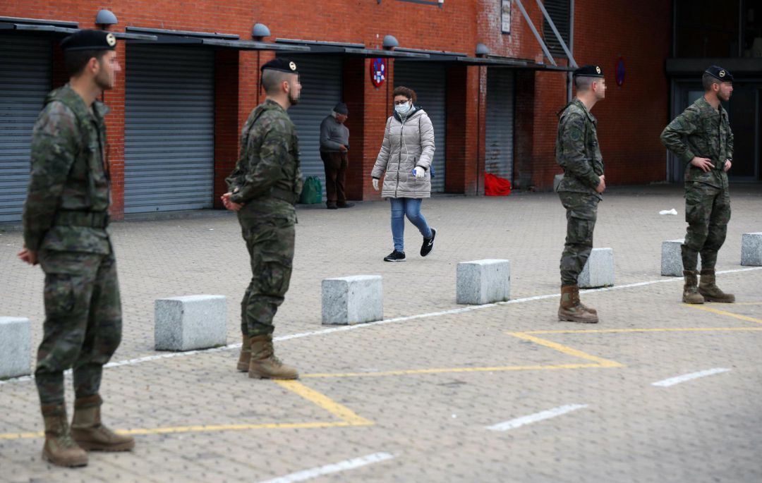 Una mujer camina con una mascarilla junto a los militares desplegados en la Operación Balmis en la estación de Atocha en Madrid este miércoles durante la cuarta jornada en estado de alarma por el coronavirus. Una mujer camina con una mascarilla junto a los militares desplegados en la Operación Balmis en la estación de Atocha en Madrid este miércoles durante la cuarta jornada en estado de alarma por el coronavirus.