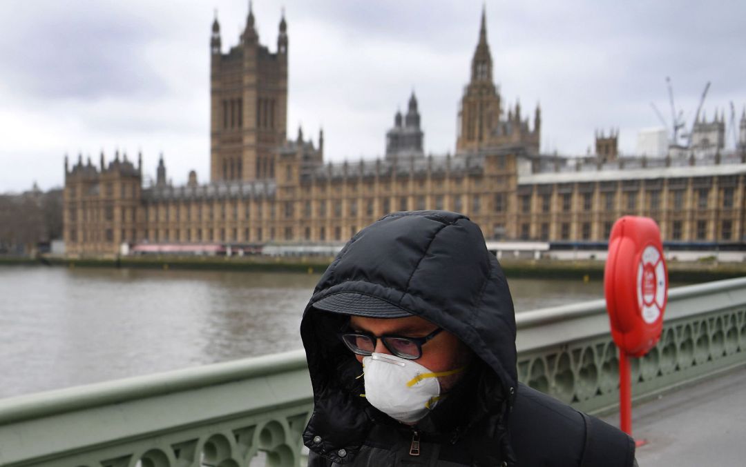 Un hombre con mascarilla junto al Parlamento británico Un hombre con mascarilla junto al Parlamento británico