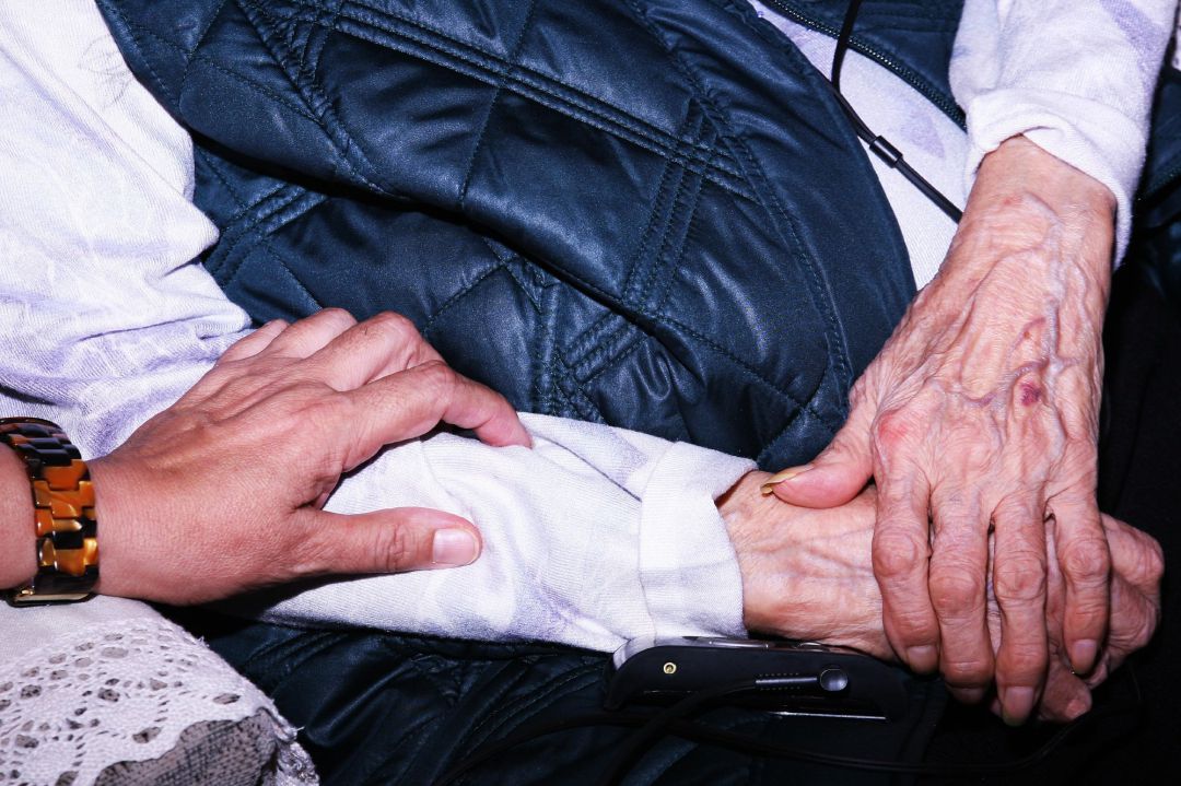 Una mujer cuidadora atiende a un anciano Una mujer cuidadora atiende a un anciano