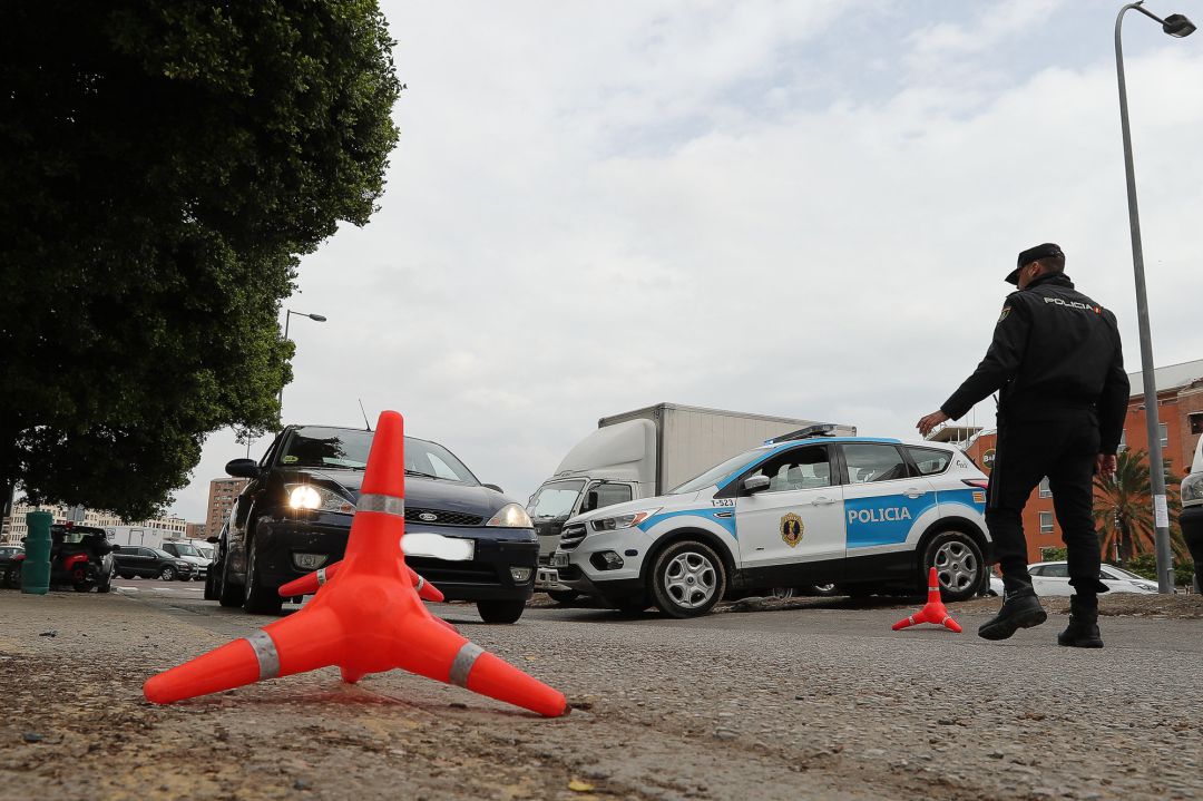 Un policía detiene a un vehículo en uno de los controles sobre los coches que abandonan la ciudad en pleno estado de alarma Un policía detiene a un vehículo en uno de los controles sobre los coches que abandonan la ciudad en pleno estado de alarma
