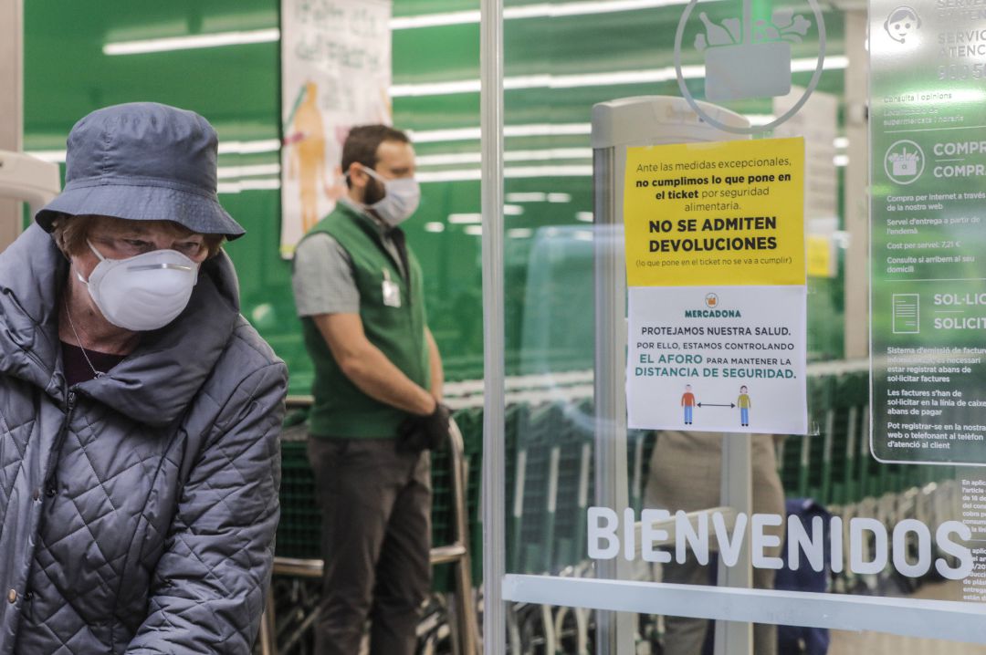 Una mujer con mascarilla a las puertas de un Mercadona. Una mujer con mascarilla a las puertas de un Mercadona.