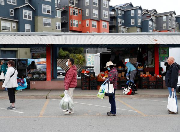 Algunos compradores en San Francisco (California) mantienen la distancia de un metro en la cola de un mercado.