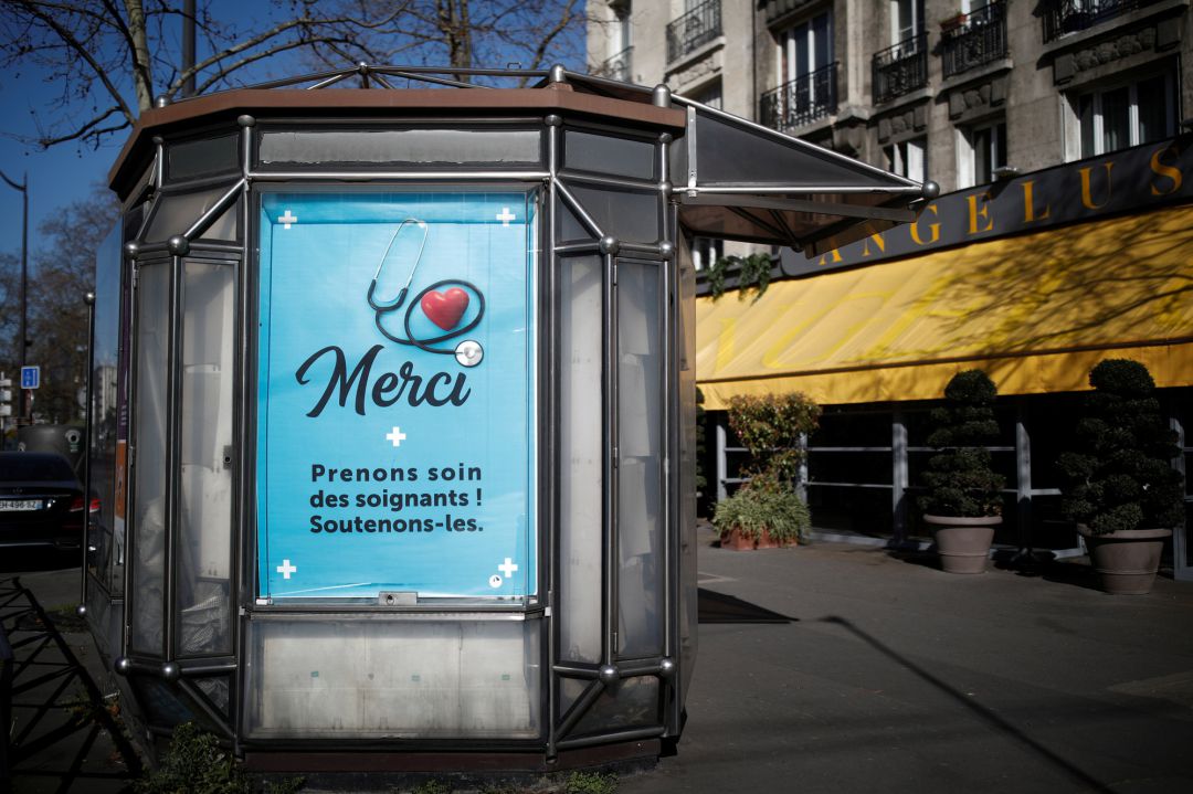 Un cartel en un quiosco de París que pide cuidar a los profesionales médicos Un cartel en un quiosco de París que pide cuidar a los profesionales médicos