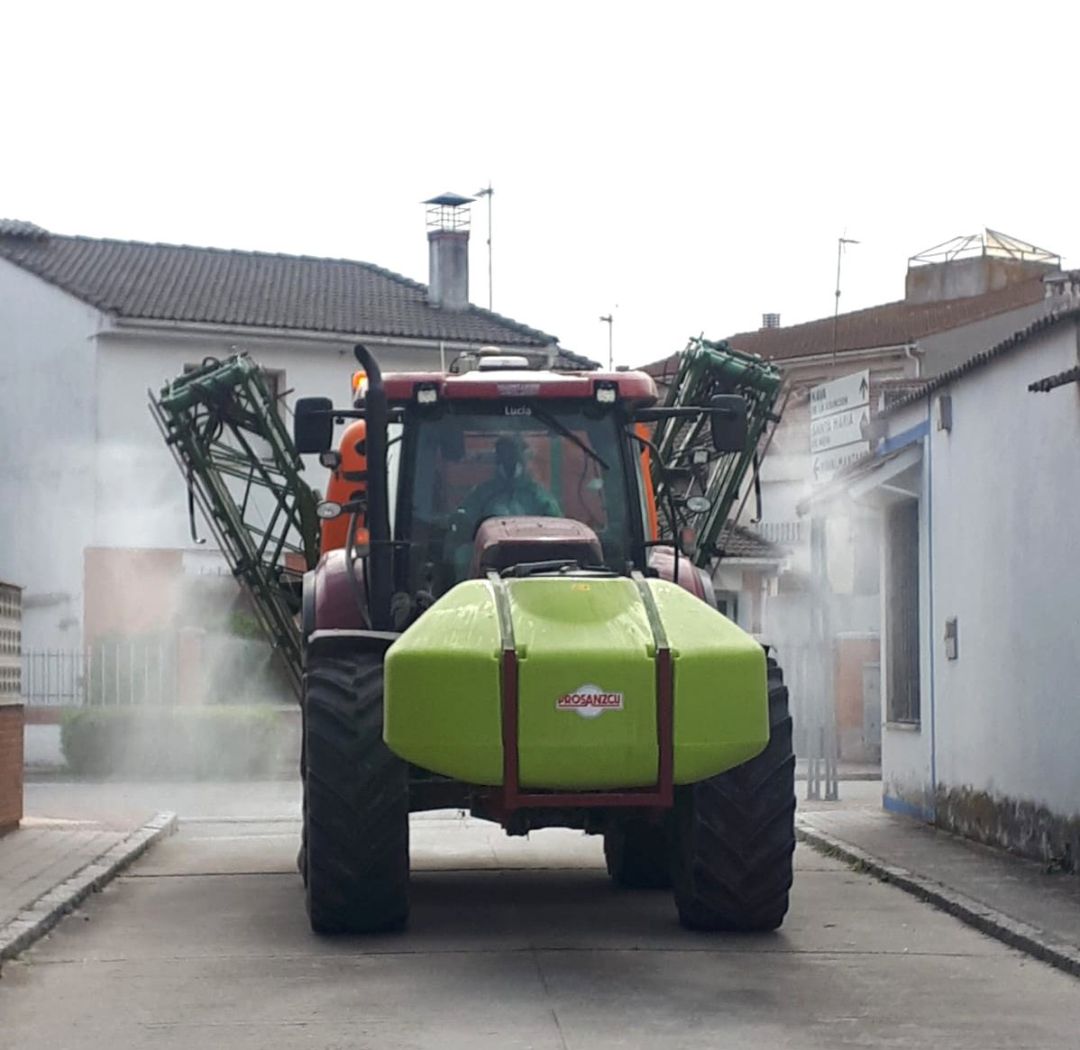 Un tractor trabaja para desinfectar las calles de un pueblo. Un tractor trabaja para desinfectar las calles de un pueblo.