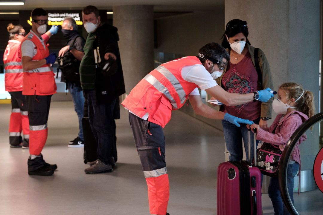 Personal de Cruz Roja toma la temperatura a los pasajeros procedentes de un vuelo Personal de Cruz Roja toma la temperatura a los pasajeros procedentes de un vuelo