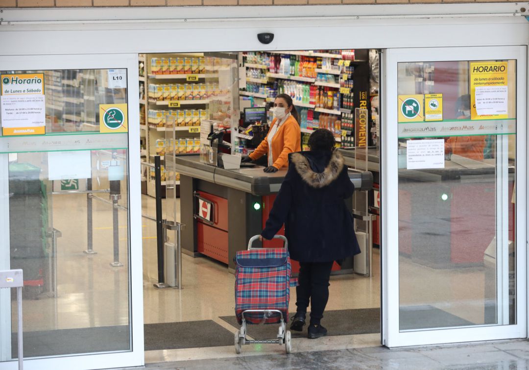 Una mujer entra a hacer la compra a un supermercado en plena crisis sanitaria por coronavirus Una mujer entra a hacer la compra a un supermercado en plena crisis sanitaria por coronavirus
