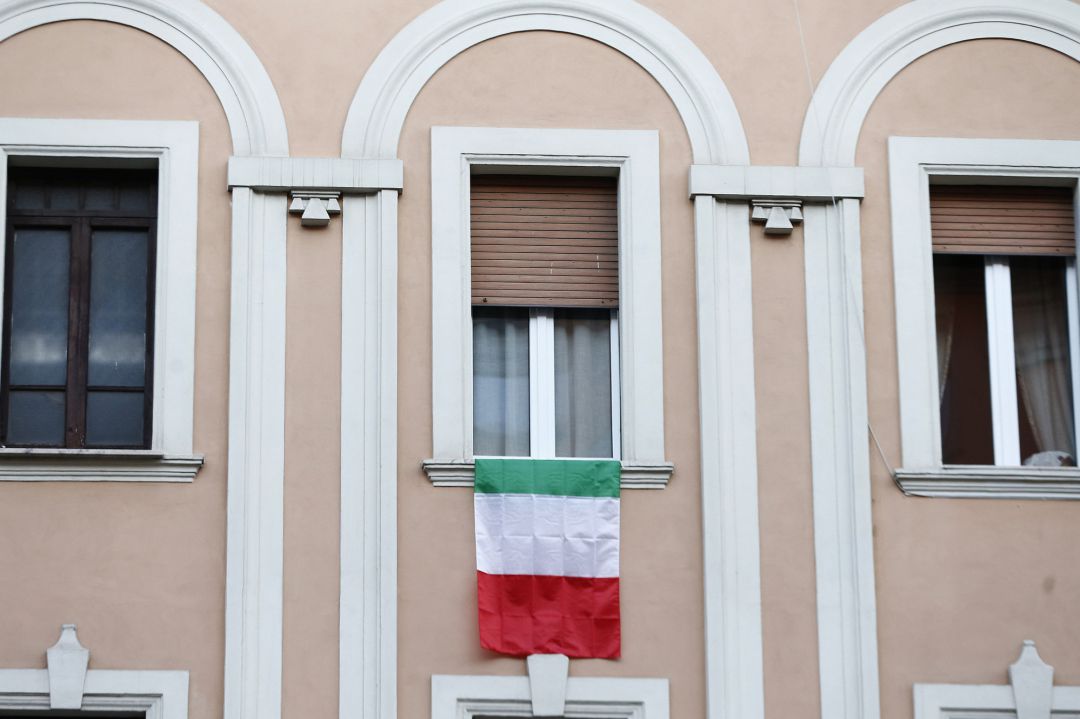 Una bandera de Italia cuelga de una ventana de un apartamento en Roma Una bandera de Italia cuelga de una ventana de un apartamento en Roma
