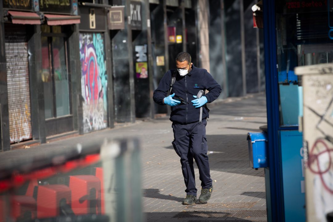 Un hombre protegido con mascarilla y guantes camina por una calle durante el noveno día laborable desde que se decretó el estado de alarma Un hombre protegido con mascarilla y guantes camina por una calle durante el noveno día laborable desde que se decretó el estado de alarma