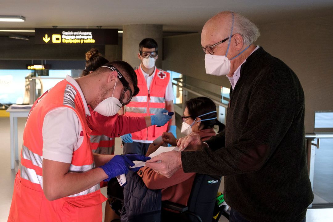 Personal de Cruz Roja toma la temperatura a los pasajeros procedentes de un vuelo de Madrid a su llegada al aeropuerto de Gran Canaria, Personal de Cruz Roja toma la temperatura a los pasajeros procedentes de un vuelo de Madrid a su llegada al aeropuerto de Gran Canaria,