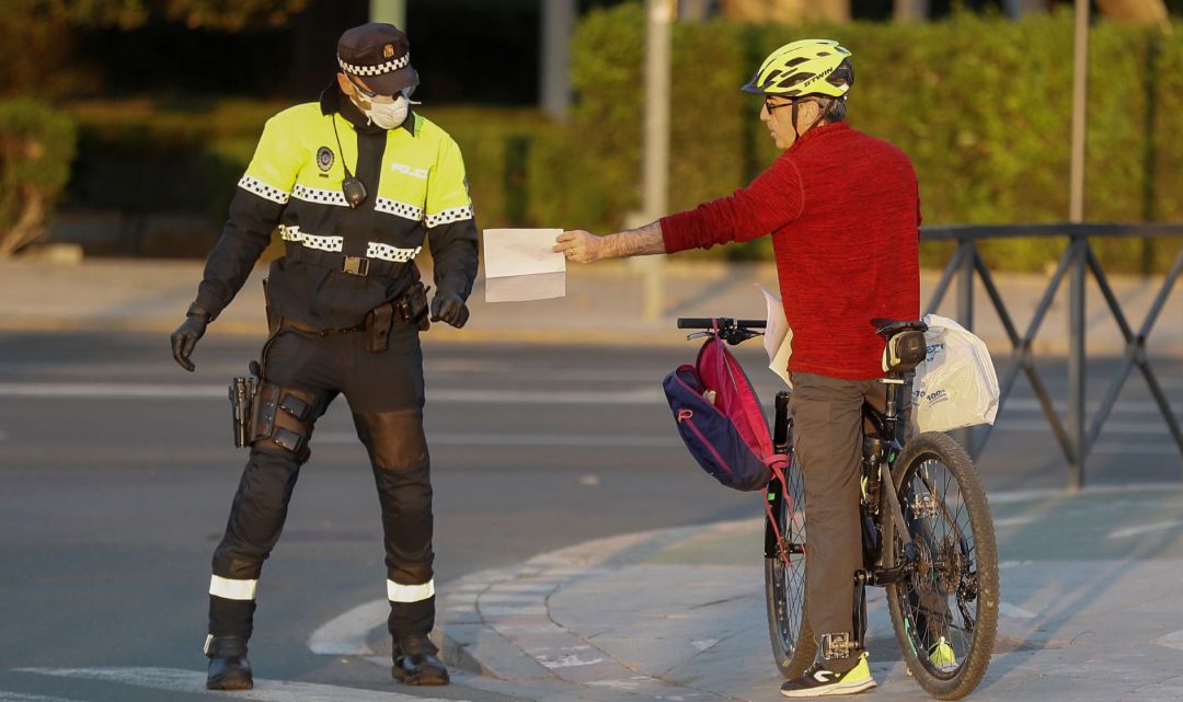 La policía local pide los papeles a un ciudadano que circulan por la calle esta tarde durante el décimo cuarto día de confinamiento tras la declaración del estado de alerta por coronavirus. La policía local pide los papeles a un ciudadano que circulan por la calle esta tarde durante el décimo cuarto día de confinamiento tras la declaración del estado de alerta por coronavirus.