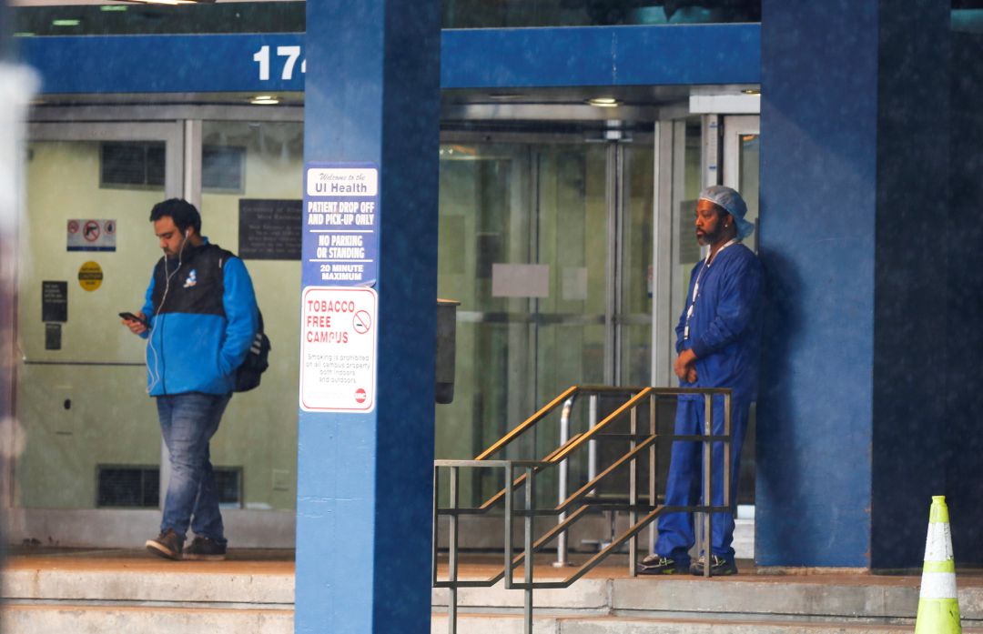 Un sanitario del Hospital Universitario de Illinois descansa en la entrada del edificio tras conocerse 12 casos positivos por coronavirus entre el personal de enfermería. Un sanitario del Hospital Universitario de Illinois descansa en la entrada del edificio tras conocerse 12 casos positivos por coronavirus entre el personal de enfermería.