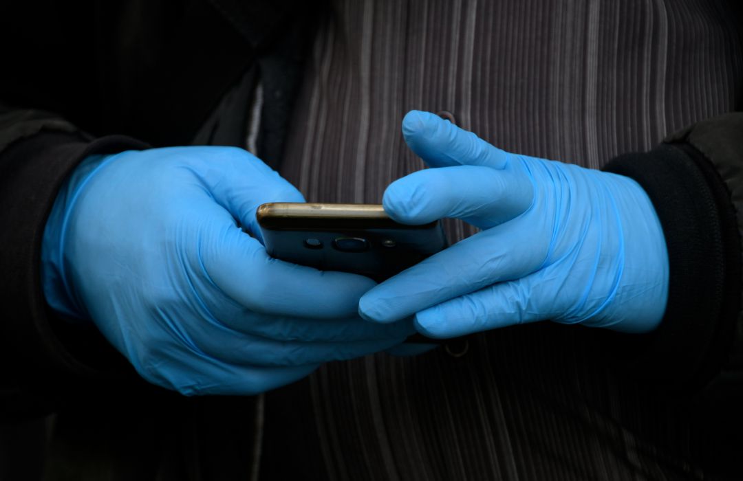 Un hombre con guantes maneja un smartphone en Madrid. Un hombre con guantes maneja un smartphone en Madrid.