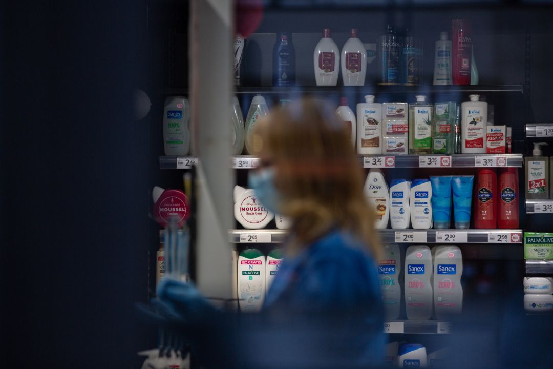 Una mujer protegida con mascarilla y guantes trabajando en una tienda en Barcelona Una mujer protegida con mascarilla y guantes trabajando en una tienda en Barcelona