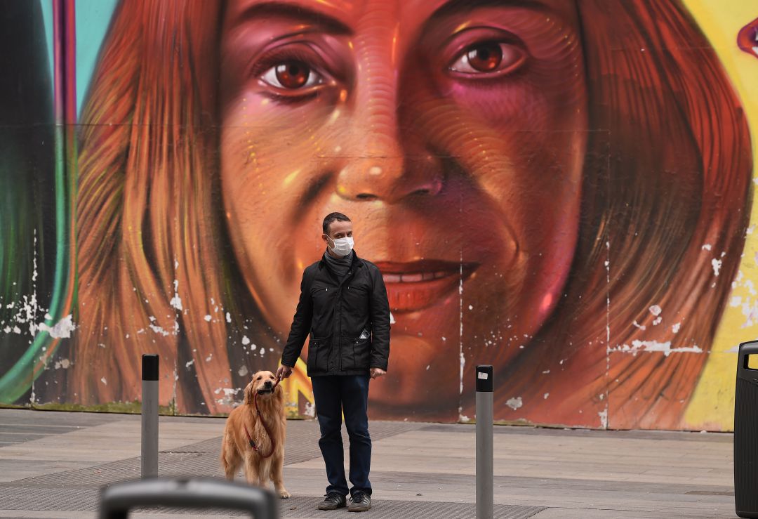 Un hombre pasea con su perro por la Gran Vía de Madrid. Un hombre pasea con su perro por la Gran Vía de Madrid.