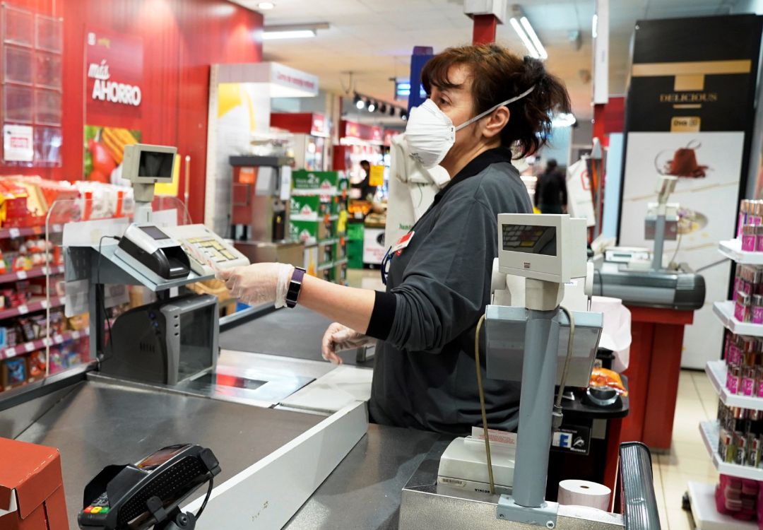 Empleada con mascarilla por coronavirus en un supermercado Empleada con mascarilla por coronavirus en un supermercado