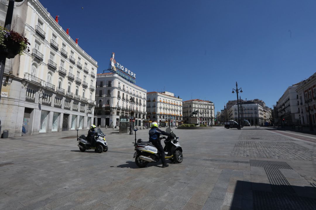 Agentes de la Policía en moto en la Puerta de Sol, desierta durante la jornada en la que en que se cumplen 21 días desde que se decretó el estado de alarma decretado por el Gobierno a consecuencia del coronavirus Agentes de la Policía en moto en la Puerta de Sol, desierta durante la jornada en la que en que se cumplen 21 días desde que se decretó el estado de alarma decretado por el Gobierno a consecuencia del coronavirus