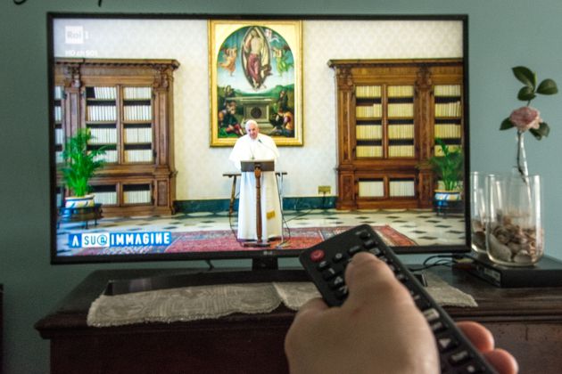 Un fiel ve una misa oficiada por el papa Francisco por la tele Un fiel ve una misa oficiada por el papa Francisco por la tele
