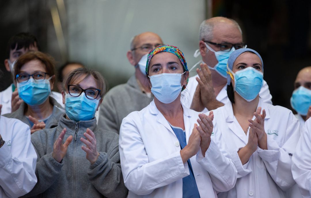 Varios profesionales sanitarios aplauden a las puertas de un hospital. Varios profesionales sanitarios aplauden a las puertas de un hospital.