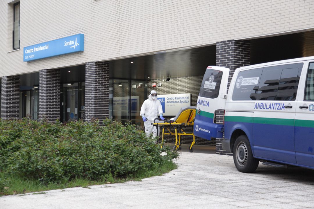 Un sanitario protegido con un traje, guantes y mascarilla, saca una camilla de una ambulancia en la entrada a la residencia Sanitas, en Vitoria Un sanitario protegido con un traje, guantes y mascarilla, saca una camilla de una ambulancia en la entrada a la residencia Sanitas, en Vitoria