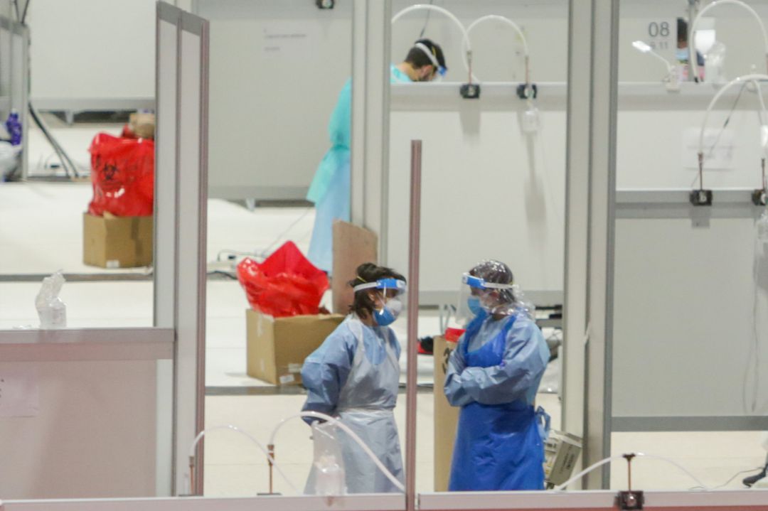 Dos sanitarios protegidos trabajan en el interior del Hospital temporal de la Comunidad de Madrid habilitado en Ifema. Dos sanitarios protegidos trabajan en el interior del Hospital temporal de la Comunidad de Madrid habilitado en Ifema.