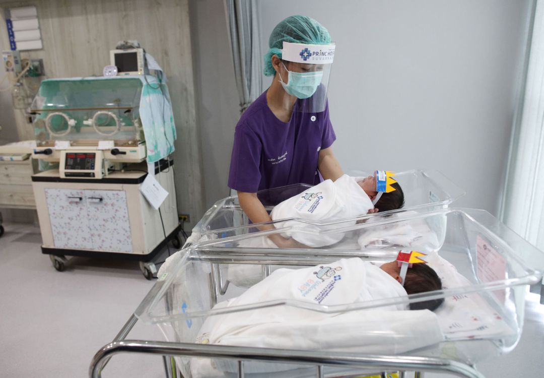 Una enfermera en Tailandia cuida a unos bebés con pantalla protectora Una enfermera en Tailandia cuida a unos bebés con pantalla protectora