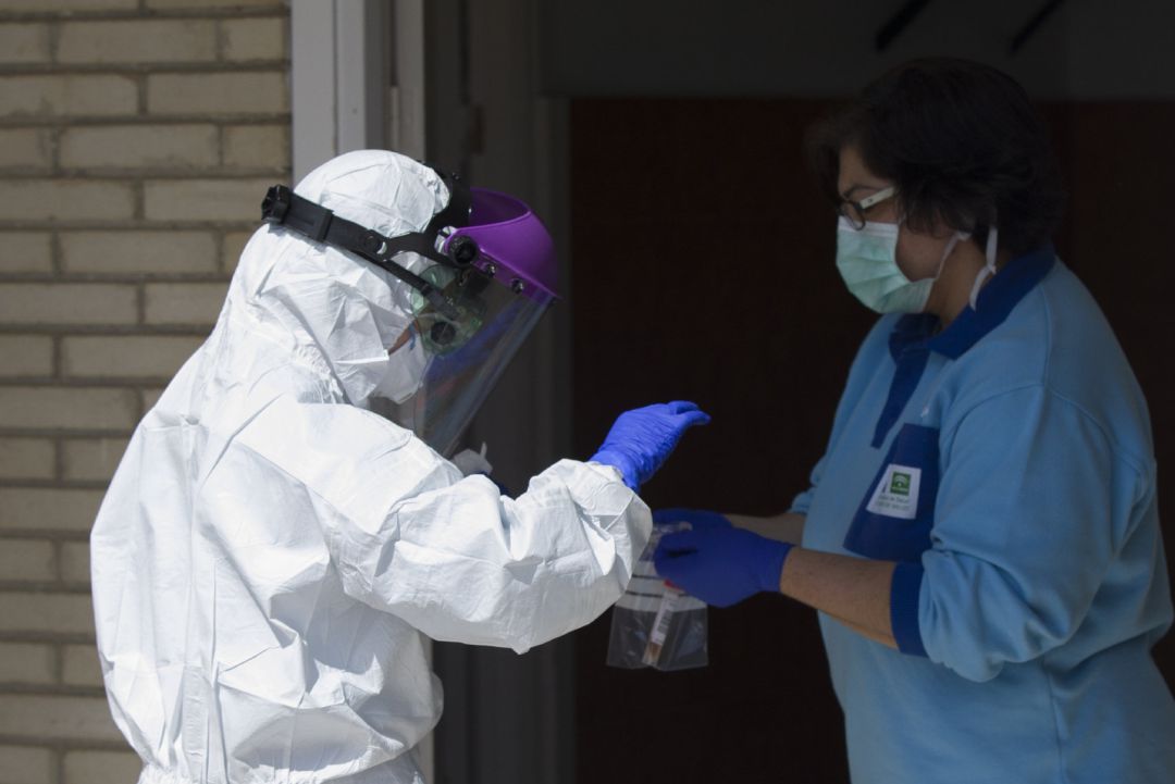 Un sanitario entrega las pruebas a otro, tras realizar una recogida de muestra desde el coche para detectar casos de coronavirus. Un sanitario entrega las pruebas a otro, tras realizar una recogida de muestra desde el coche para detectar casos de coronavirus.