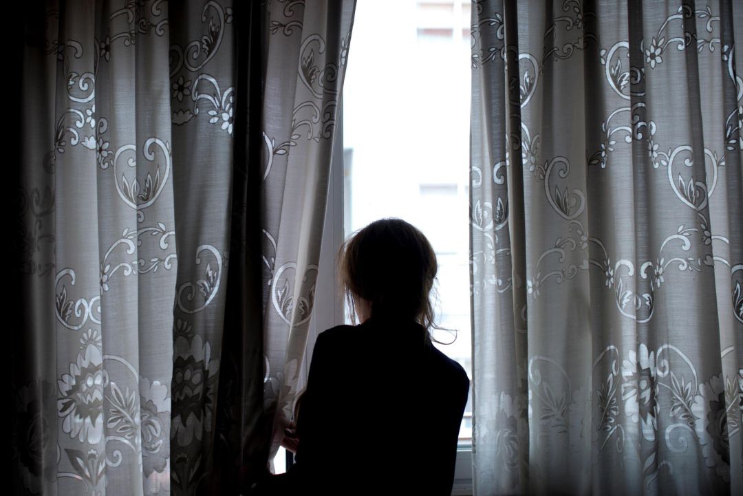 Una mujer observa a través de la ventana de su vivienda, en la que permanece confinada desde que el Gobierno decretase el estado de alarma por la crisis del coronavirus Una mujer observa a través de la ventana de su vivienda, en la que permanece confinada desde que el Gobierno decretase el estado de alarma por la crisis del coronavirus