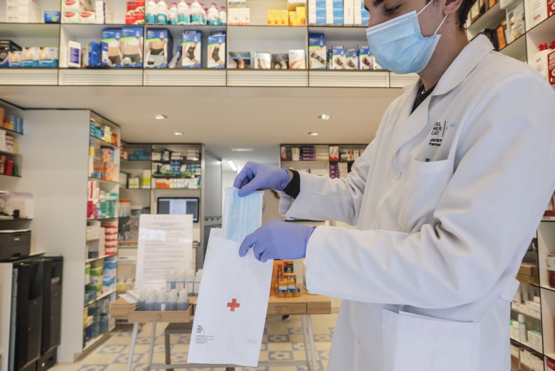 Un farmacéutico da una mascarilla durante el reparto de mascarillas gratuitas contra el Covid19 a mayores de 65 años y colectivos de riesgo que ayer arrancó en la Comunitat Valenciana. Después de algunas colas a primera hora en determinadas poblaciones, la distribución se ha llevado a cabo con normalidad, en Valencia Un farmacéutico da una mascarilla durante el reparto de mascarillas gratuitas contra el Covid19 a mayores de 65 años y colectivos de riesgo que ayer arrancó en la Comunitat Valenciana. Después de algunas colas a primera hora en determinadas poblaciones, la distribución se ha llevado a cabo con normalidad, en Valencia