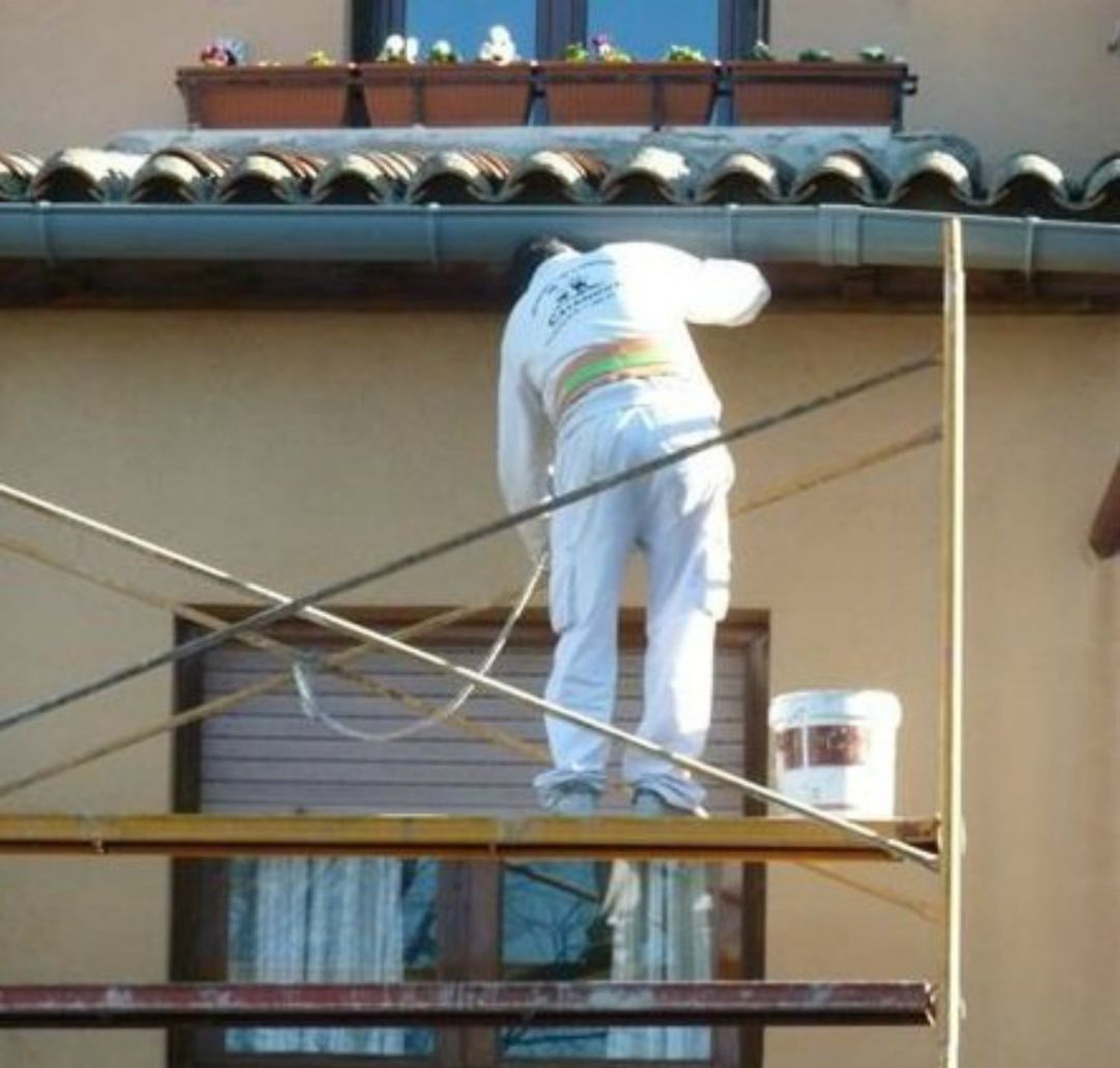 Un operario adecenta una fachada Un operario adecenta una fachada