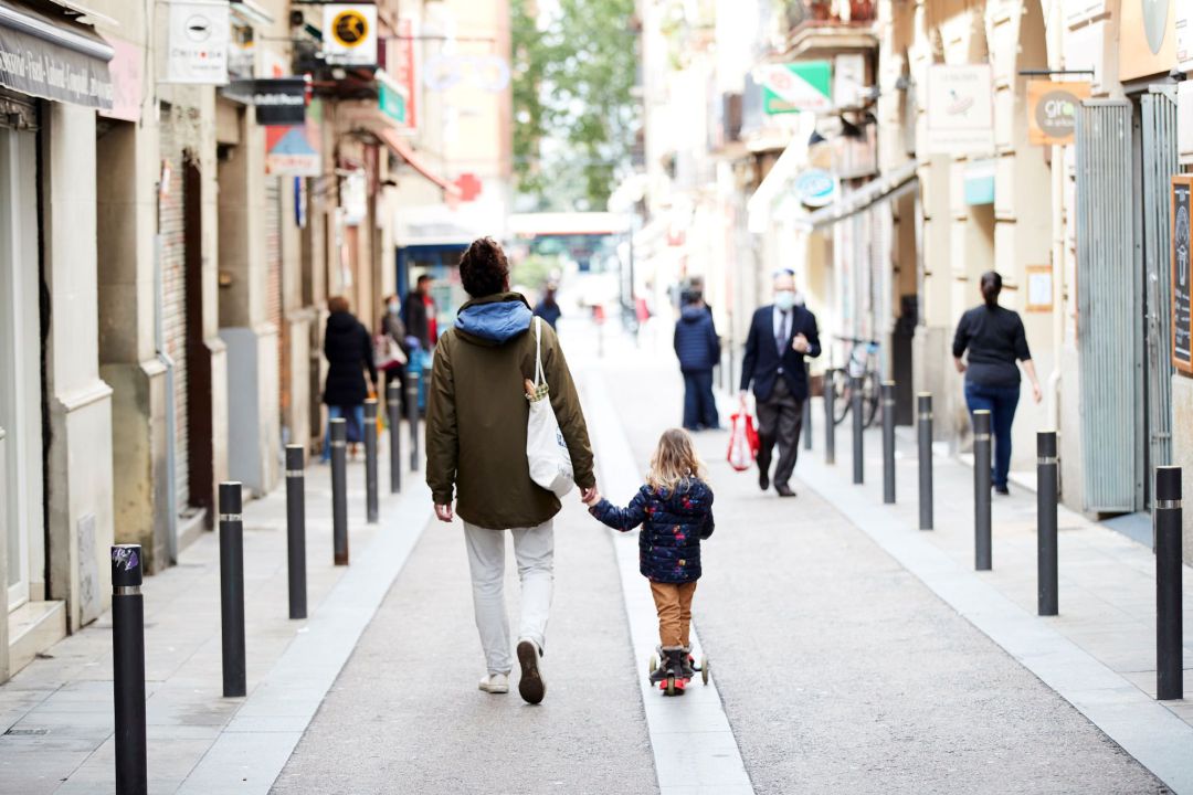 Un hombre y una niña caminan por el barrio de Gracia de Barcelona Un hombre y una niña caminan por el barrio de Gracia de Barcelona