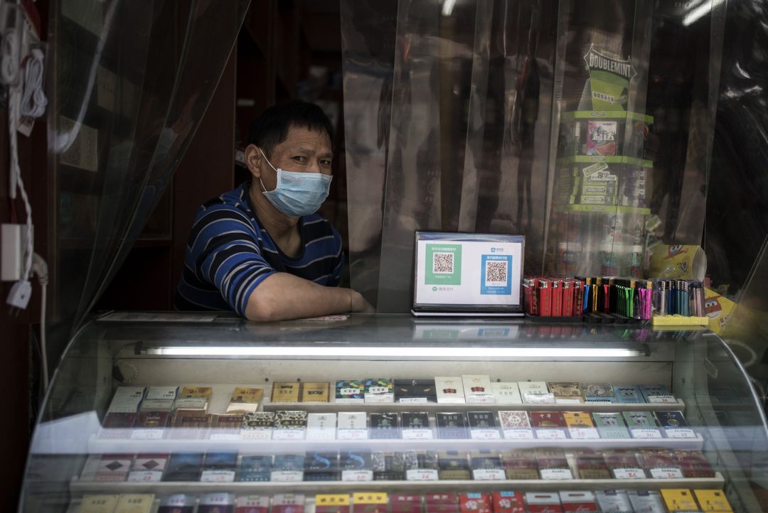 Propietario de un establecimiento con mascarilla en Wuhan. Propietario de un establecimiento con mascarilla en Wuhan.