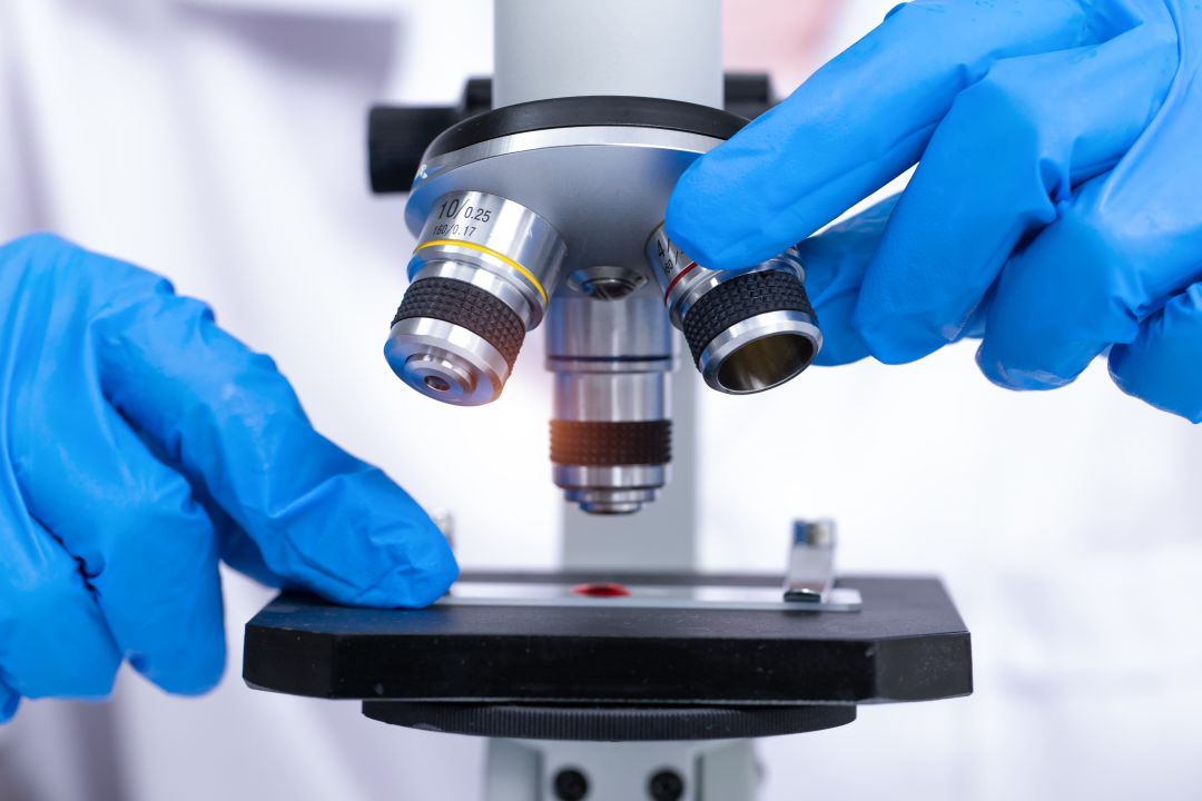 Un investigador analiza una muestra con el microscopio. Un investigador analiza una muestra con el microscopio.