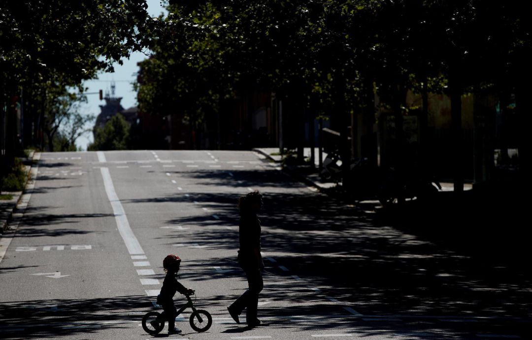 Un niño en bicicleta acompaña a su madre en una calle de Barcelona. Un niño en bicicleta acompaña a su madre en una calle de Barcelona.