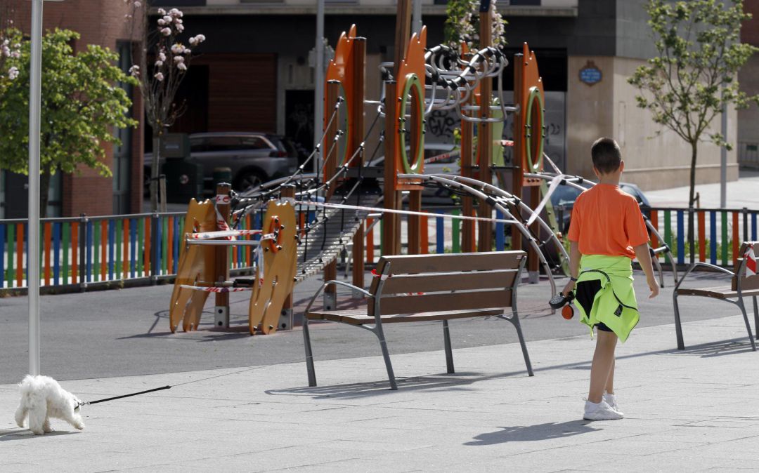 Un niño pasea el perro junto a un parque cerca de su casa este lunes en la capital vizcaína. Un niño pasea el perro junto a un parque cerca de su casa este lunes en la capital vizcaína.