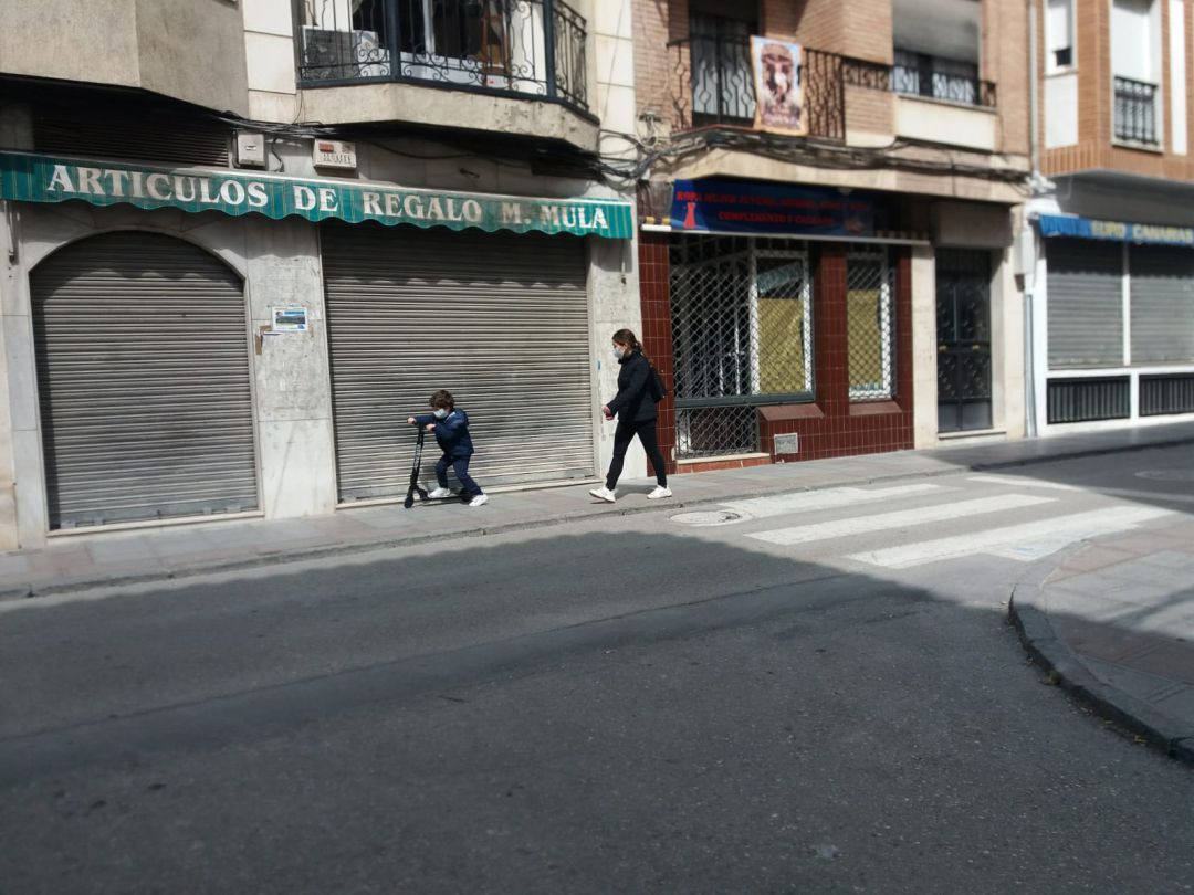 Un niño pasea con su madre, por la calle General Fresneda Un niño pasea con su madre, por la calle General Fresneda