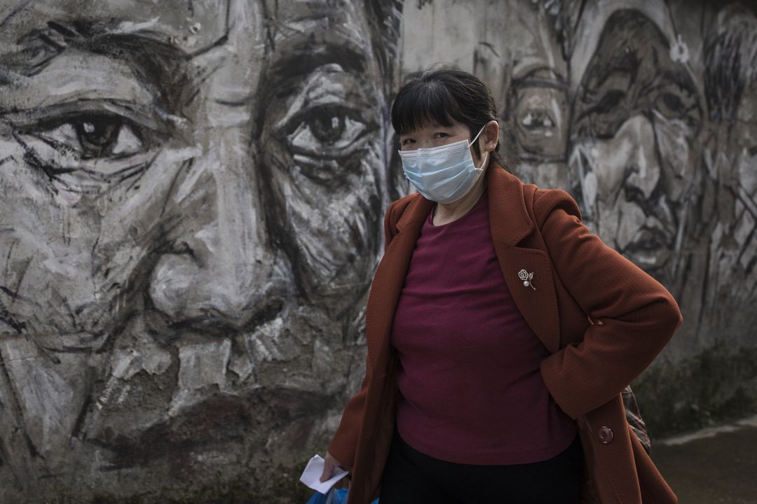 Una habitante de Wuhan camina con mascarilla. Una habitante de Wuhan camina con mascarilla.
