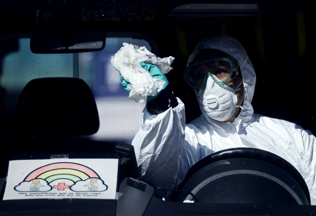 Un profesional sanitario desinfectando una ambulancia Un profesional sanitario desinfectando una ambulancia
