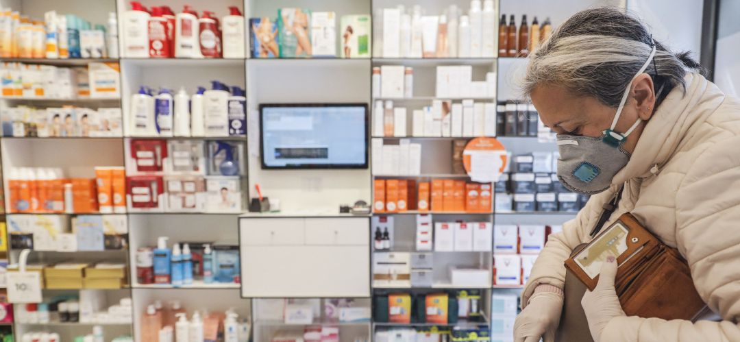 Una mujer acude a una farmacia para recoger una mascarilla Una mujer acude a una farmacia para recoger una mascarilla