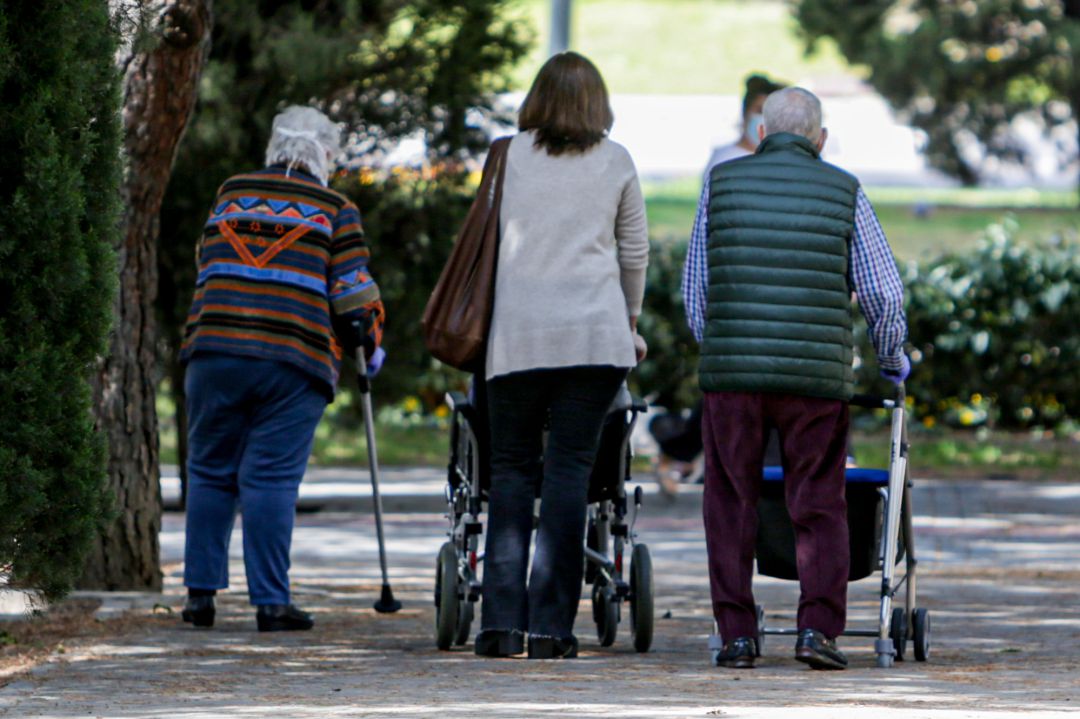 Dos ancianos y una mujer en el primer día en que los españoles pueden salir de casa a pasear y hacer ejercicio al aire libre Dos ancianos y una mujer en el primer día en que los españoles pueden salir de casa a pasear y hacer ejercicio al aire libre