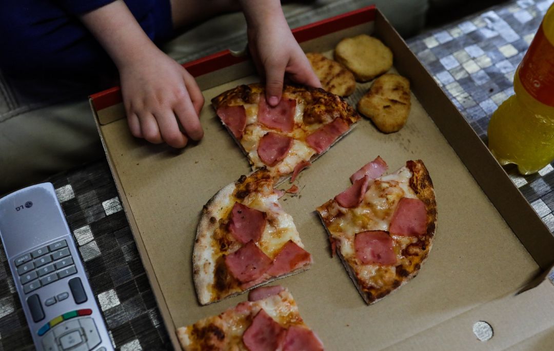 Un niño come pizza del menú infantil de Telepizza. Un niño come pizza del menú infantil de Telepizza.