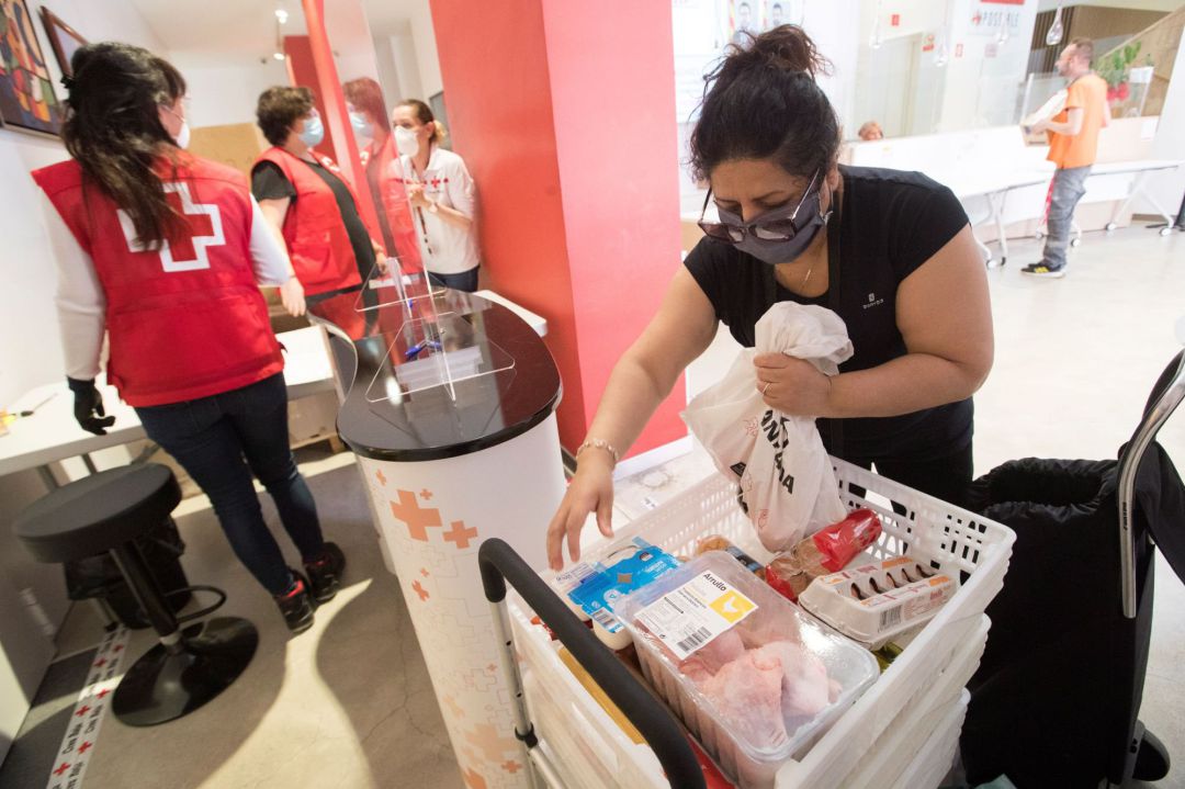 Una ciudadana recoge su lote de alimentación básica en el almacén de la Cruz Roja en Barcelona Una ciudadana recoge su lote de alimentación básica en el almacén de la Cruz Roja en Barcelona