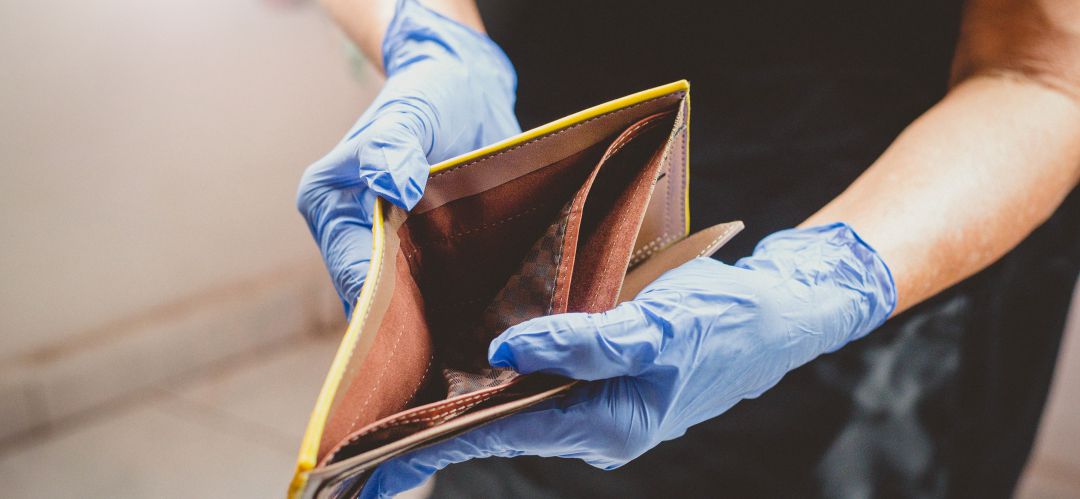 Un autónomo con las manos enguantadas enseña su cartera vacía tras el largo cierre del negocio por el COVID-19 Un autónomo con las manos enguantadas enseña su cartera vacía tras el largo cierre del negocio por el COVID-19