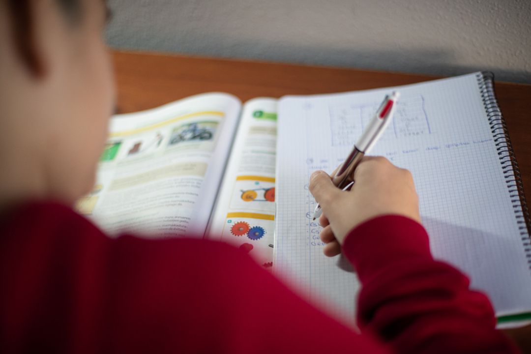 Un nen fent tasques escolars Un nen fent tasques escolars