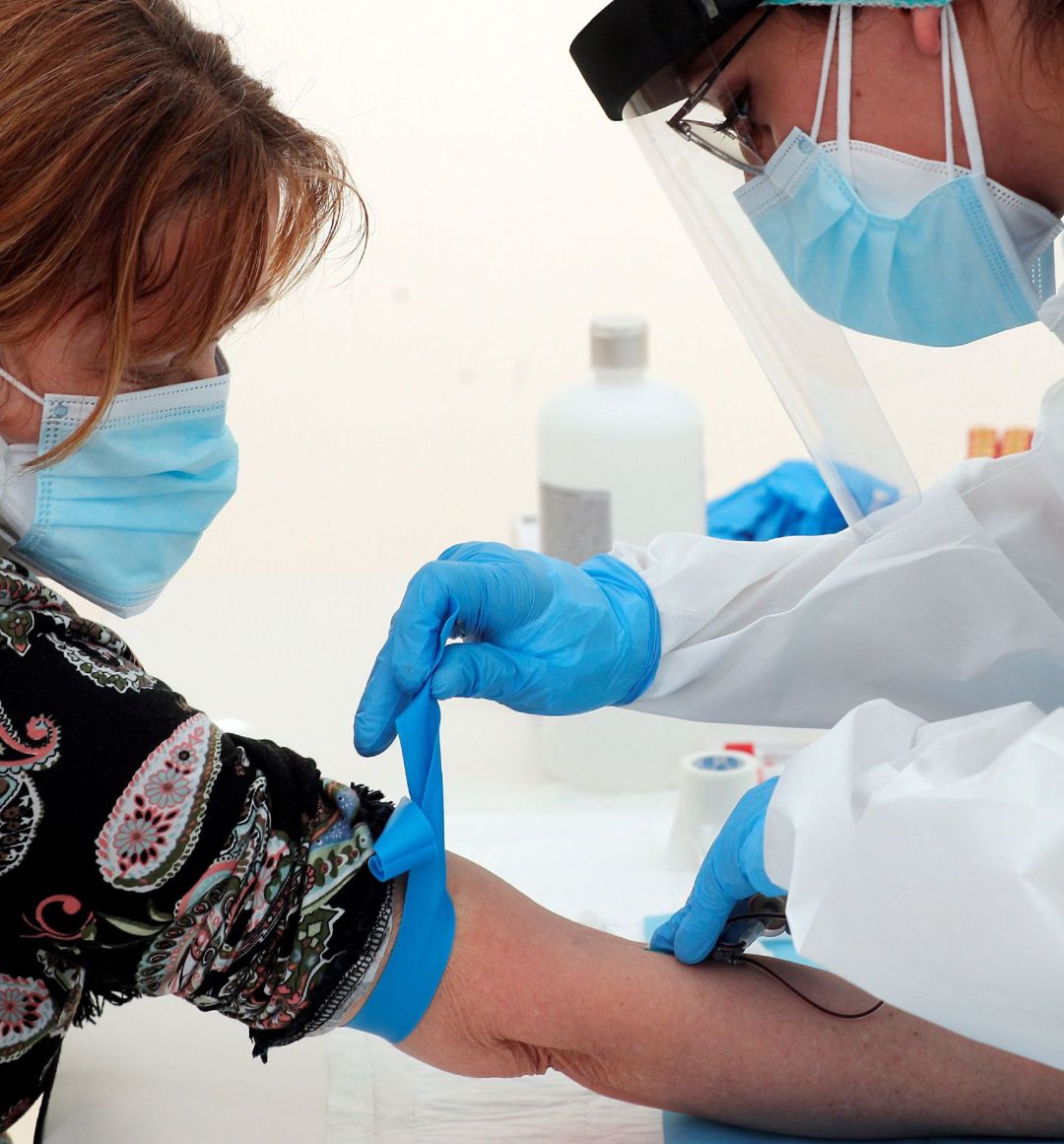 Una sanitaria le realiza una prueba a una paciente. Una sanitaria le realiza una prueba a una paciente.