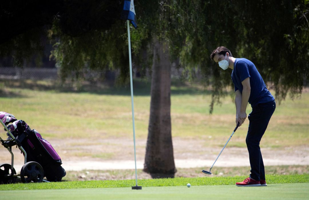 Un jugador de golf con mascarilla. Un jugador de golf con mascarilla.