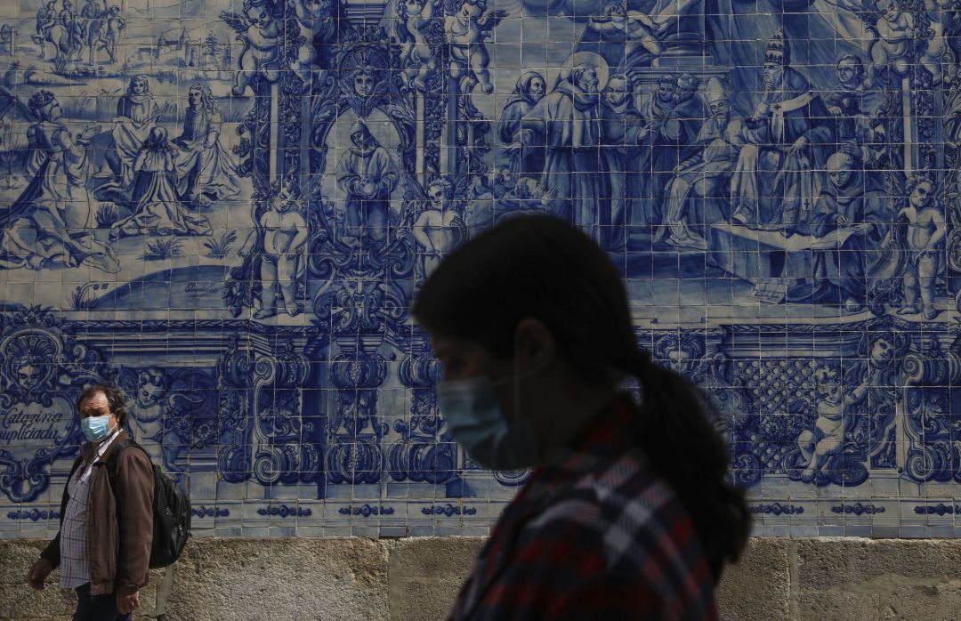 Dos personas caminan por una calle de la ciudad de Oporto con mascarilla. Dos personas caminan por una calle de la ciudad de Oporto con mascarilla.
