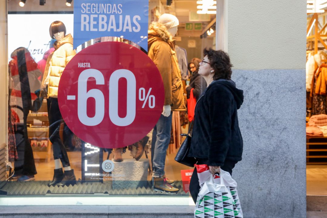 Una mujer pasea junto a una tienda de moda de Madrid Una mujer pasea junto a una tienda de moda de Madrid