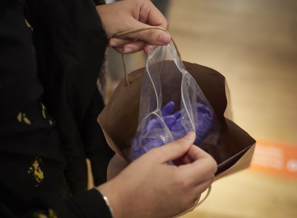 Una trabajadora de una tienda de moda abre un paquete con guantes de protección.
