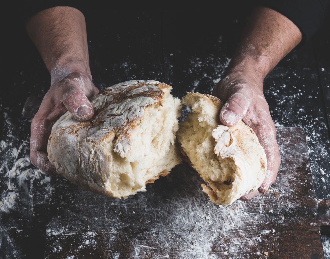 Hogaza de pan en las manos de un maestro panadero Hogaza de pan en las manos de un maestro panadero