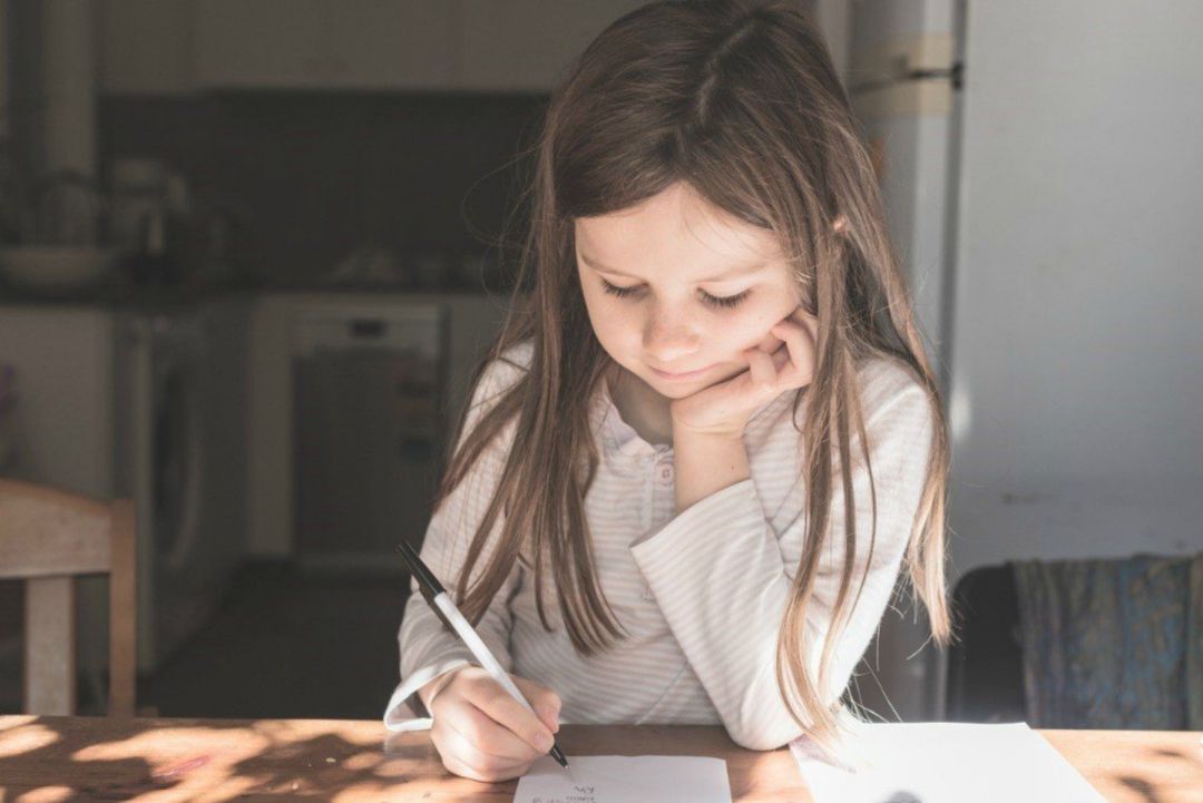 Una niña hace los deberes escolares. Una niña hace los deberes escolares.